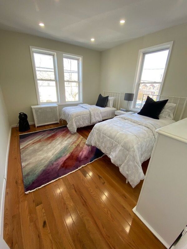 Bedroom with two beds and hardwood floors