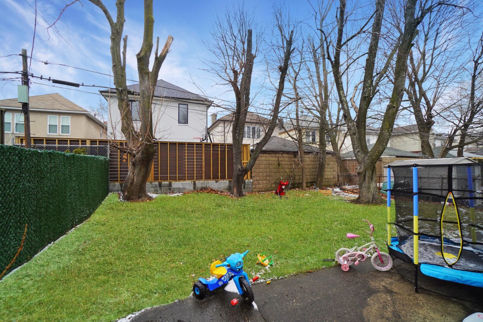 A Habayit backyard with a trampoline and children's bikes